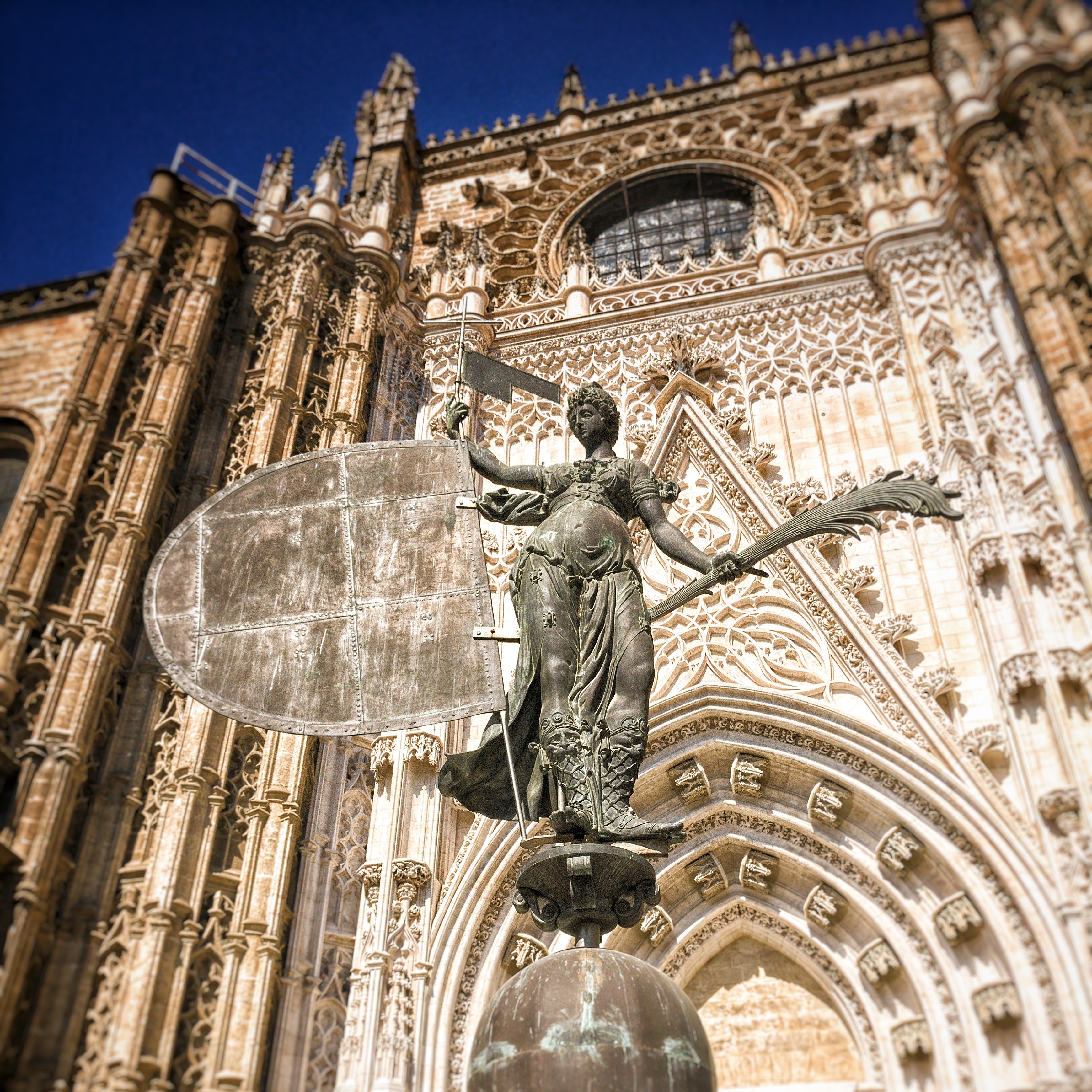 A picture of the replica of the statue on top of the Giralda in front of the entrance of the Cathedral of Sevilla.